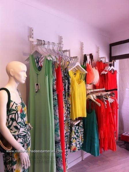 Un maniquí está parado frente a una exhibición de ropa.