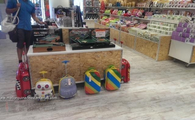 Un hombre está de pie en una tienda mirando una exhibición de equipaje.