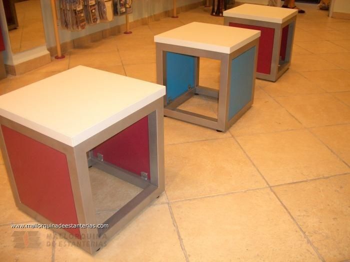 Una fila de cubos de colores sobre un suelo de baldosas.