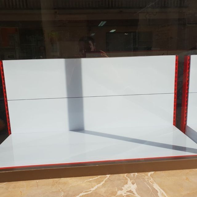 Un estante blanco con borde rojo está sobre una mesa.