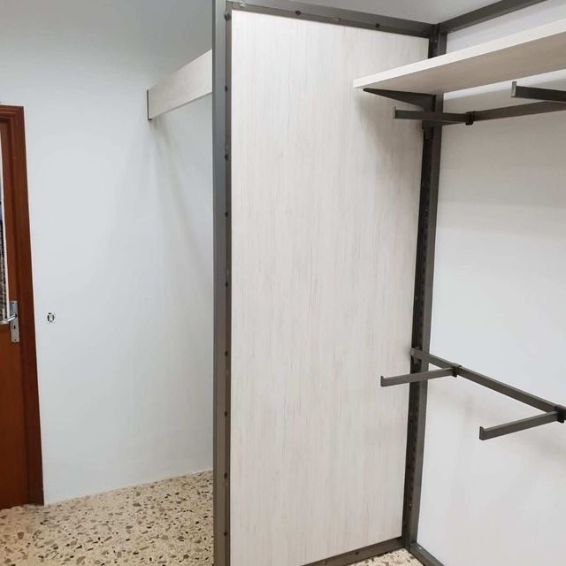 Un vestidor con espejo y estantes.