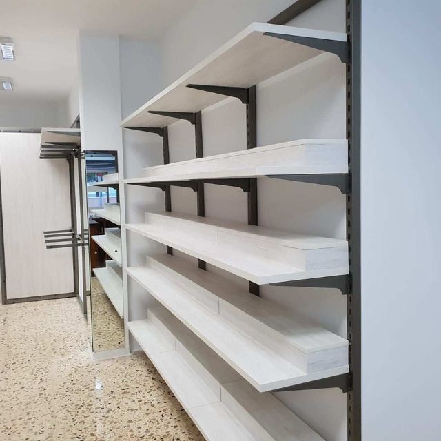 Una habitación con muchos estantes y un espejo.