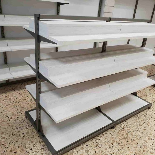 Una fila de estantes blancos se encuentran sobre un piso de baldosas.