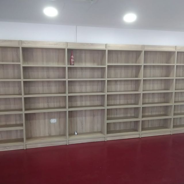 Una habitación con muchos estantes y un suelo rojo.