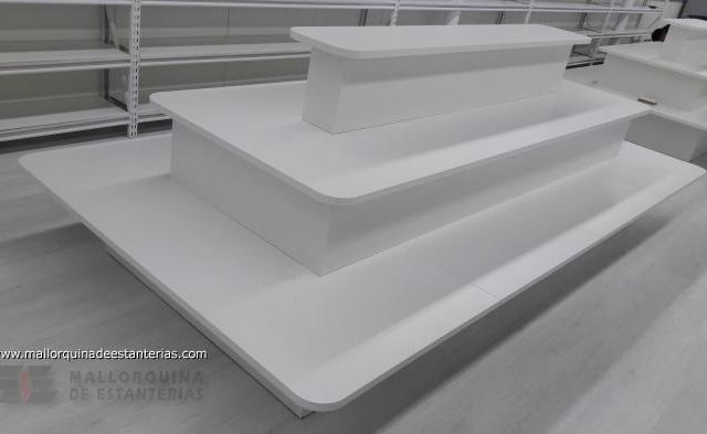 Tres mesas blancas están apiladas una encima de otra en una habitación.