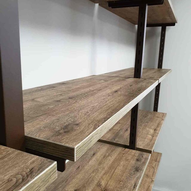 En una habitación hay un estante de madera con marco de metal.