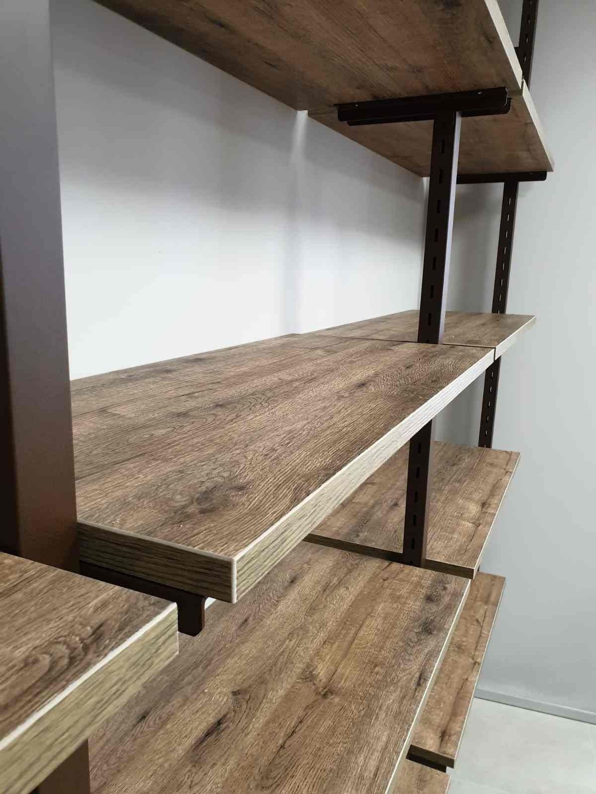 Una fila de estantes de madera contra una pared blanca en una habitación.