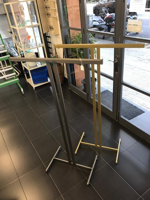 Un perchero está en una habitación al lado de una ventana.