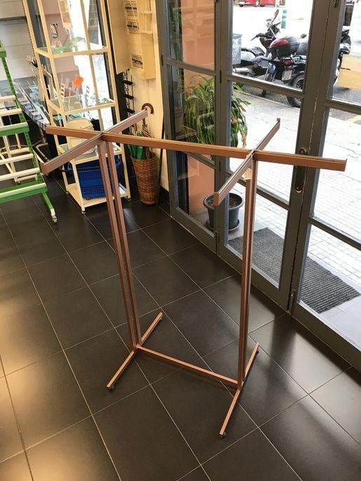 Un perchero de cobre está colocado sobre un suelo de baldosas en una habitación.