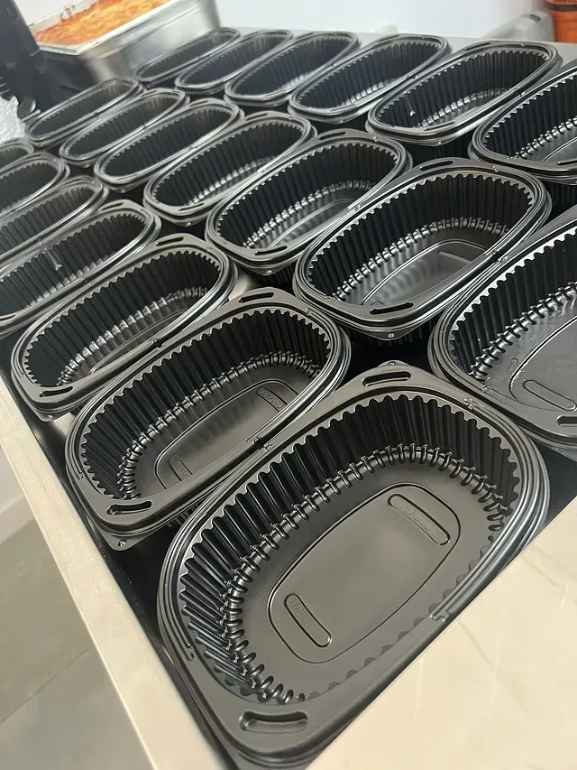 Un montón de contenedores de plástico están encima de una mesa.