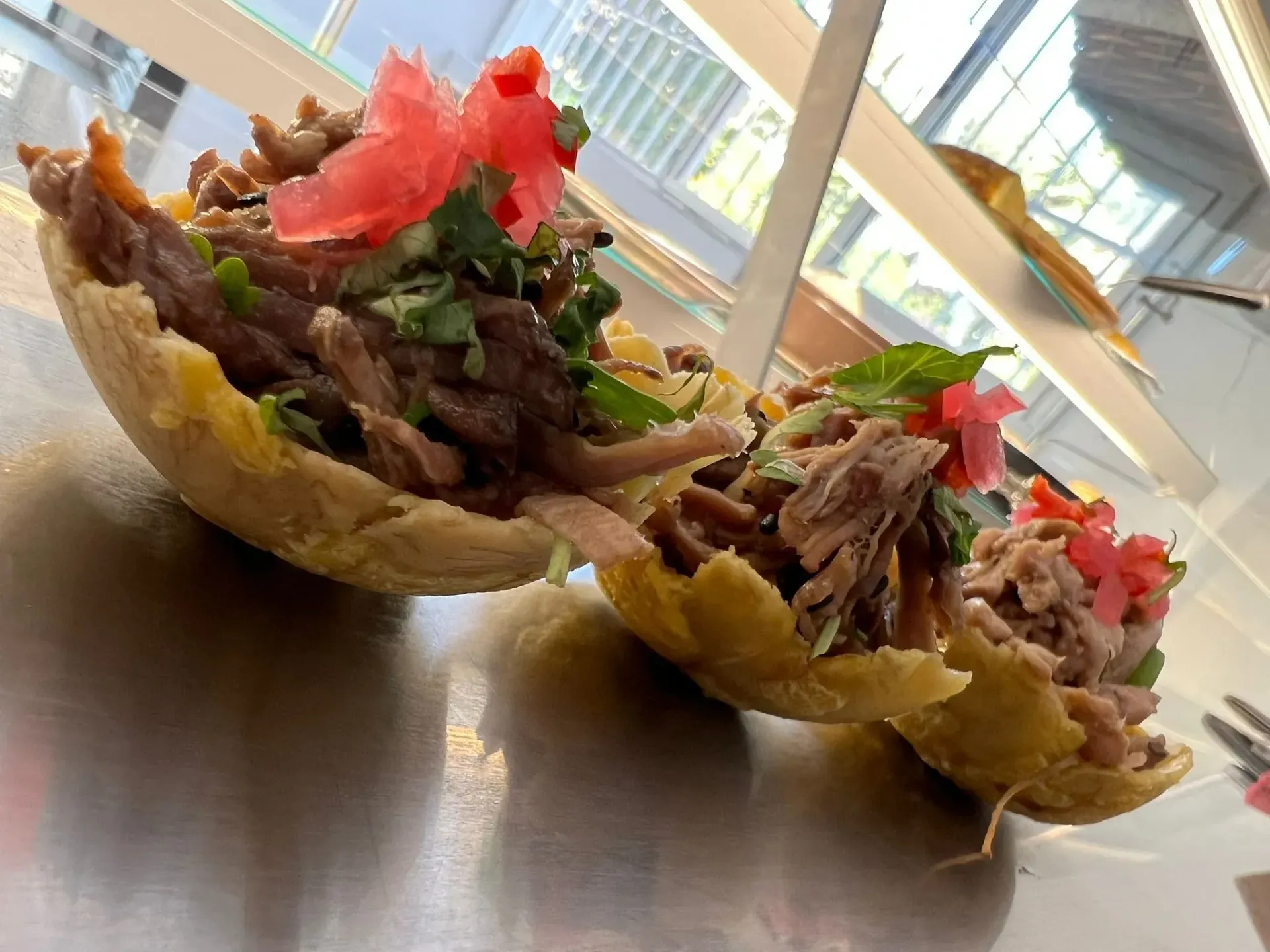 Tres cuencos de comida con carne y verduras sobre una mesa.