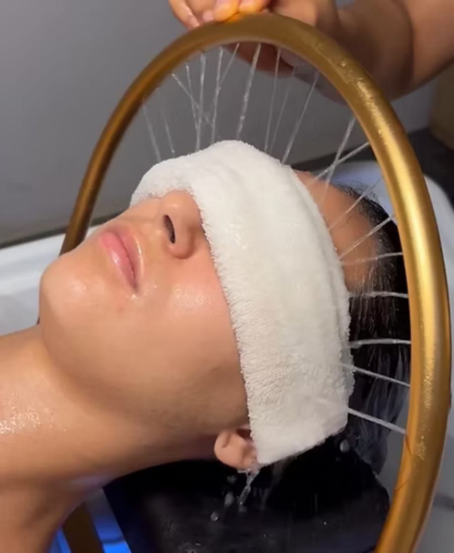 Una mujer se lava el cabello en un lavabo de una peluquería.