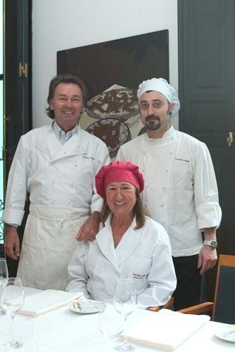 Tres chefs posan para una fotografía en un restaurante.