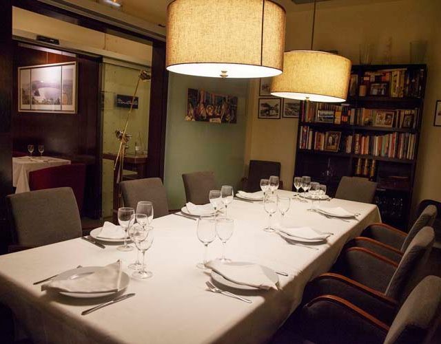 Una mesa larga con platos y vasos encima.