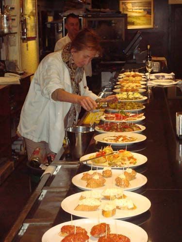 Una mujer está preparando comida en un mostrador de un restaurante.