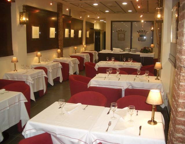 Un restaurante lleno de mesas, sillas y lámparas.