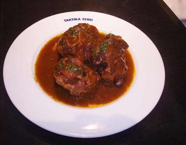 Un plato blanco con una salsa marrón encima que dice 'takyka'.