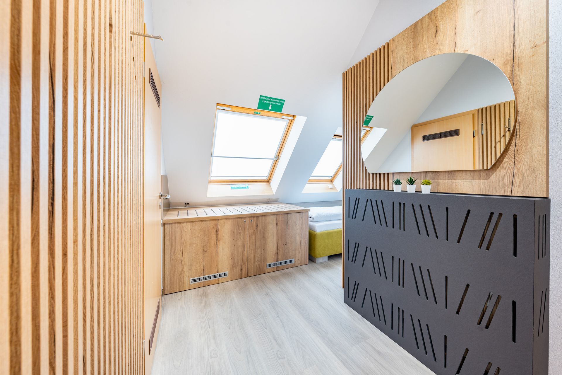 Modernes Interieur mit Holzelementen, darunter eine Wand mit Spiegel und gemusterter Verkleidung.