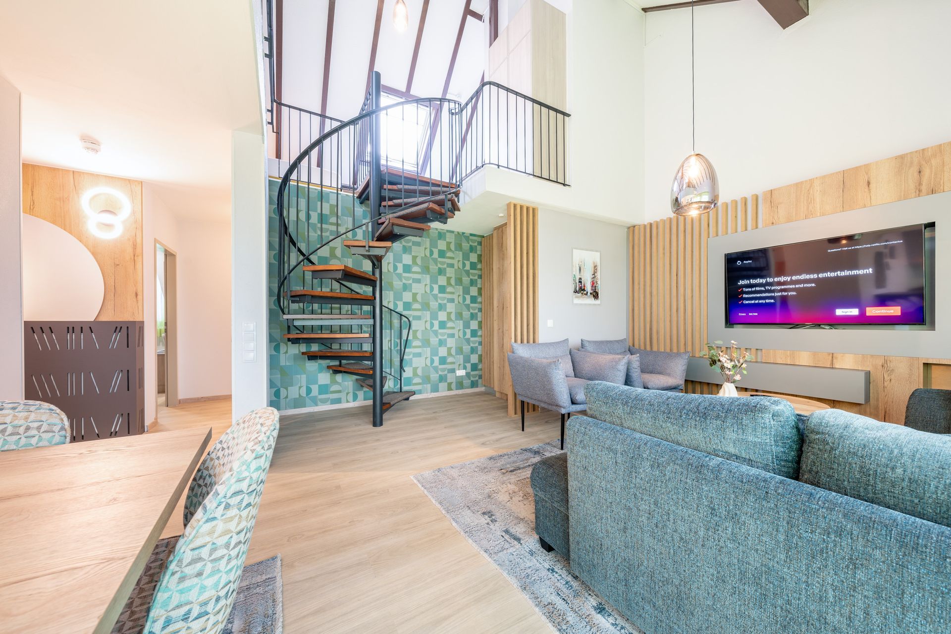 Modernes Wohnzimmer mit Wendeltreppe, türkisfarbenen Akzenten und Holzvertäfelung.