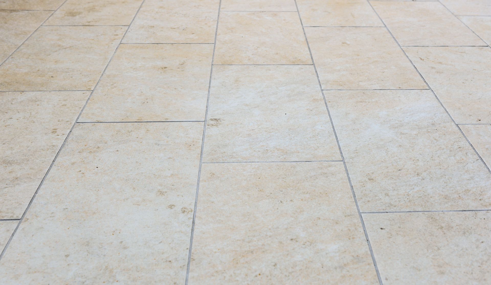 Gros plan sur des pavés en pierre disposés selon un motif de grille rectangulaire répétitif.