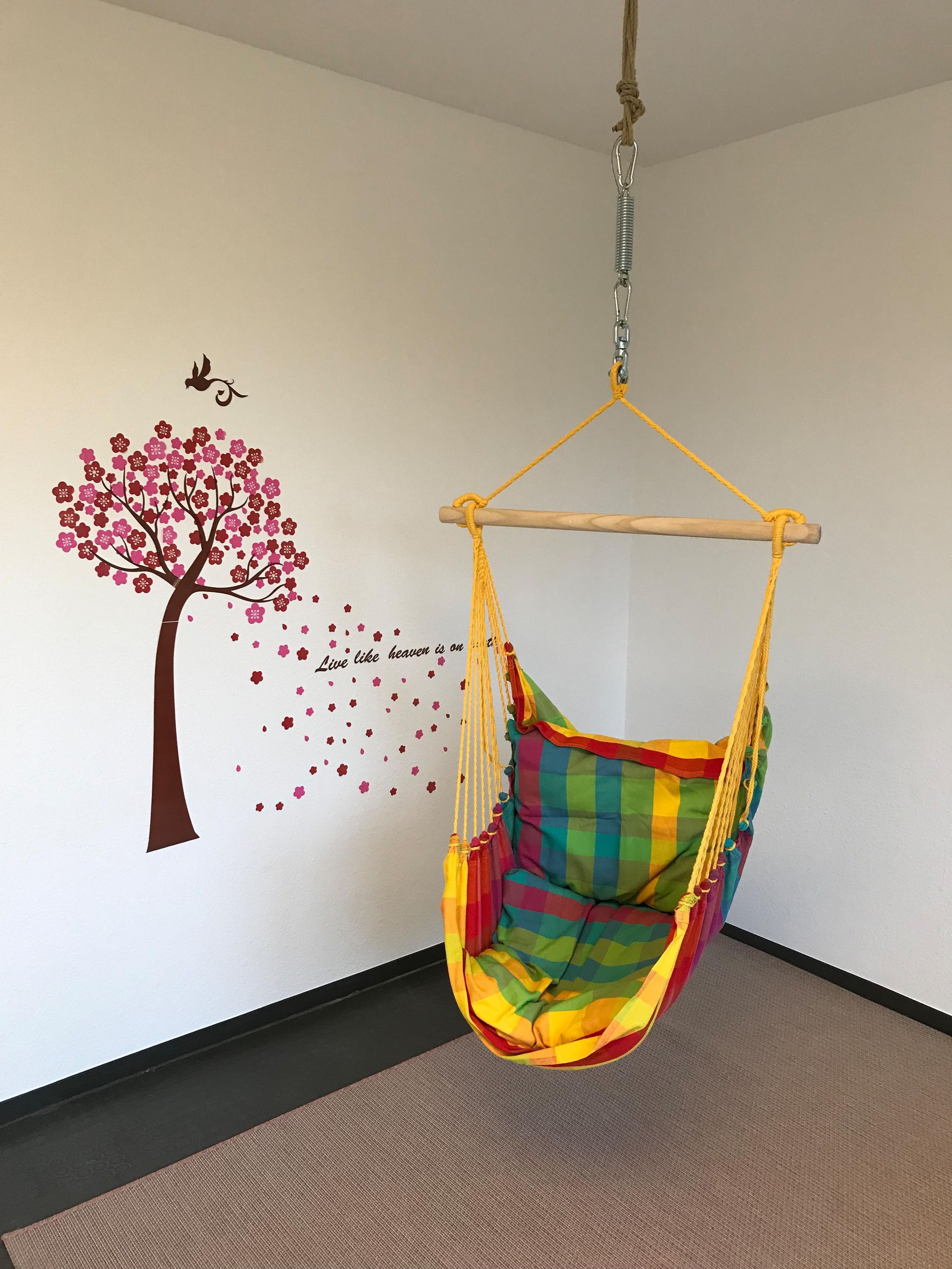 Eine bunte Hängematte hängt von der Decke in einem Raum