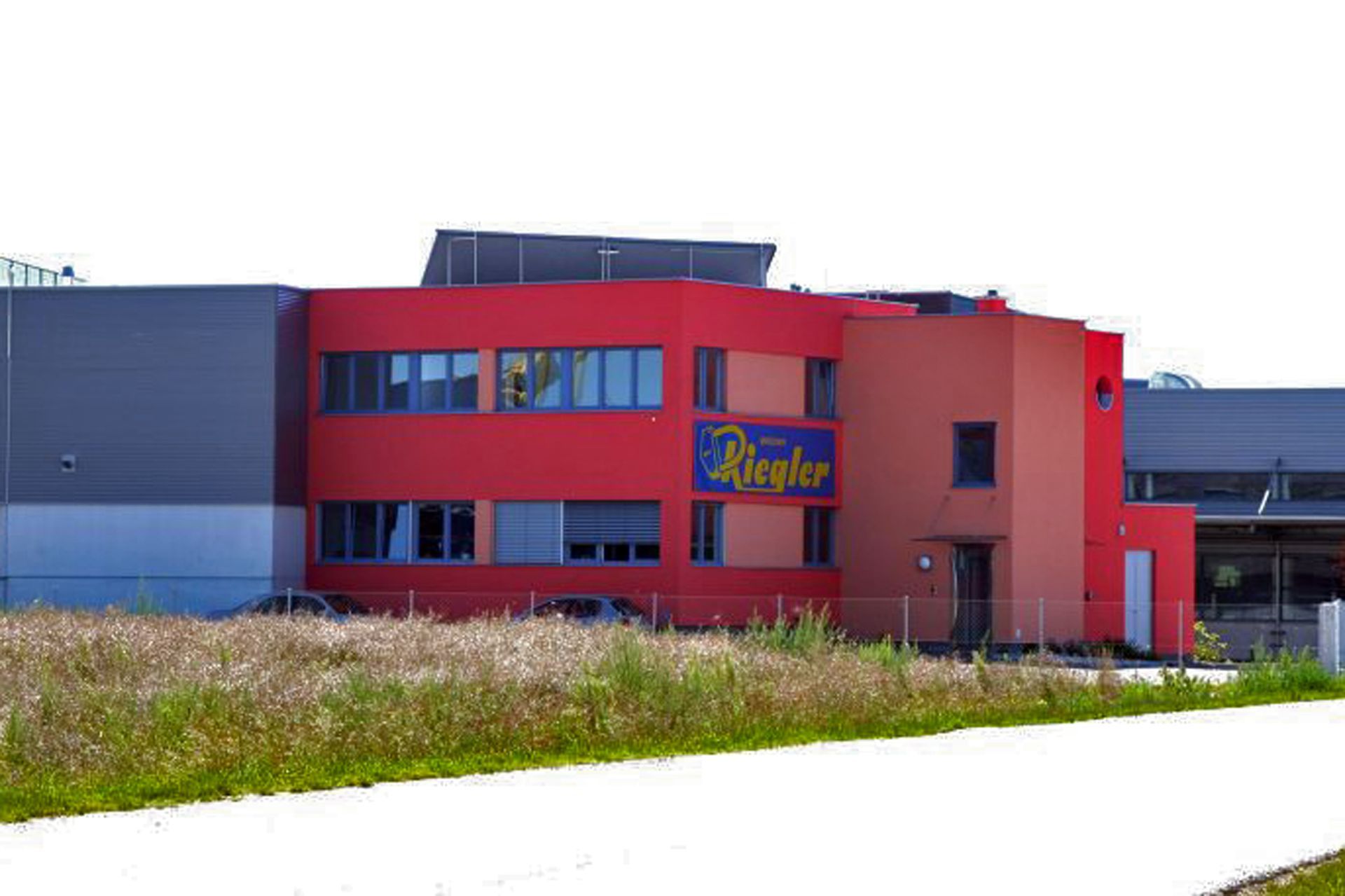 Ein großes rotes Gebäude mit einem blauen Schild an der Seite.