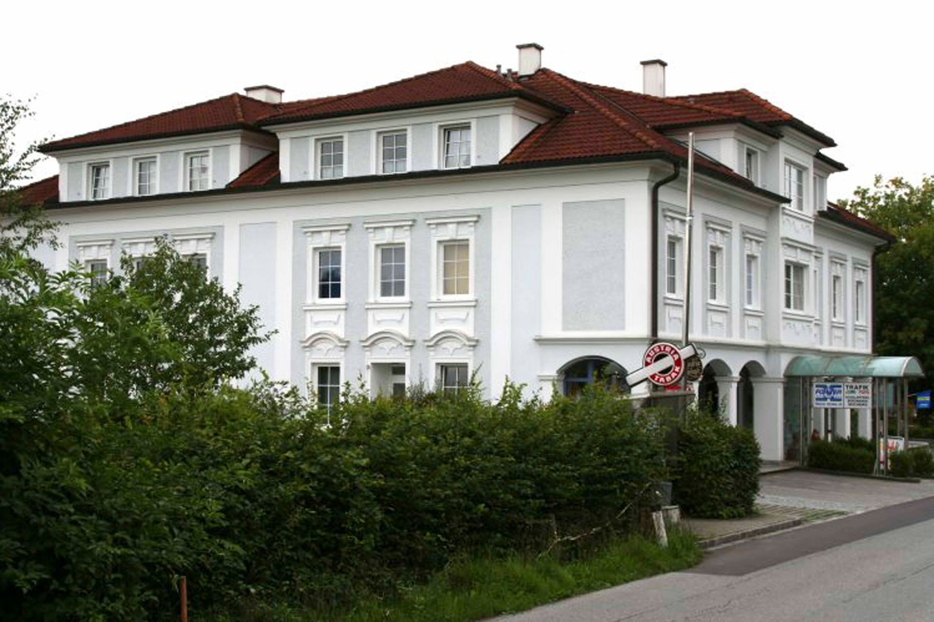 Ein großes weißes Gebäude mit einem roten Ziegeldach