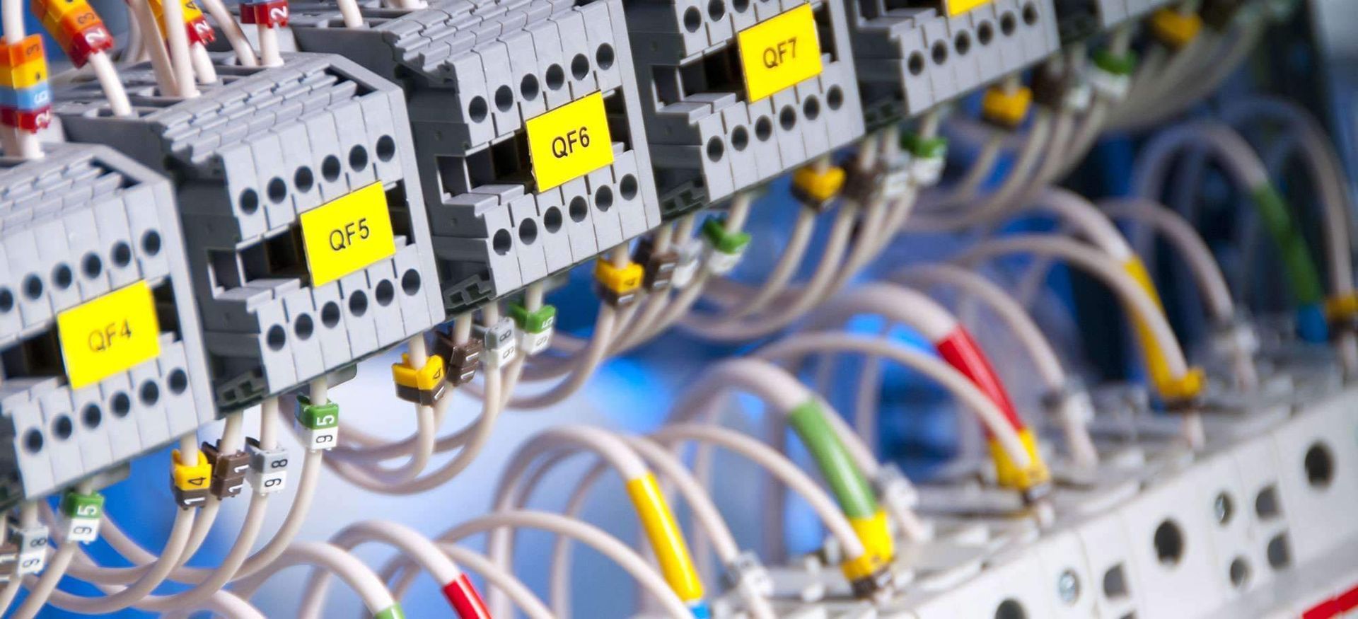 Elektrischer Schaltschrank mit Reihen von Leistungsschaltern, Verkabelung und gelben Etiketten