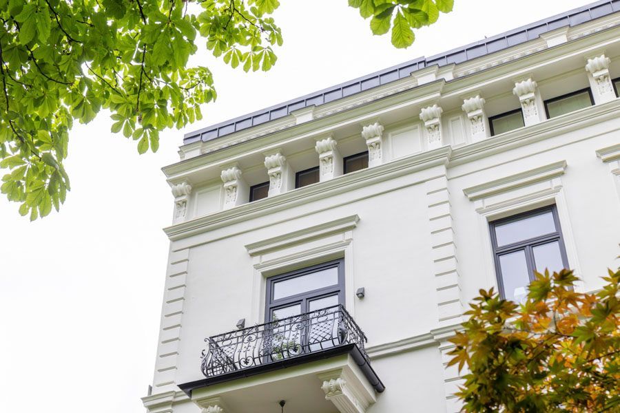 Ein weißes Gebäude mit einem Balkon und einer Feuertreppe