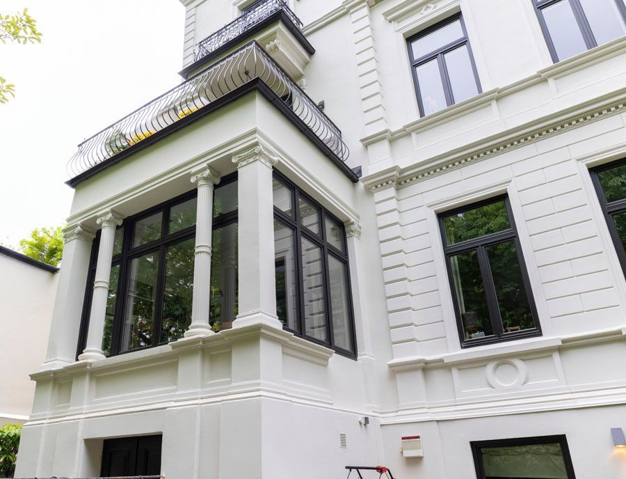 Ein großes weißes Gebäude mit schwarzen Fenstern und Säulen