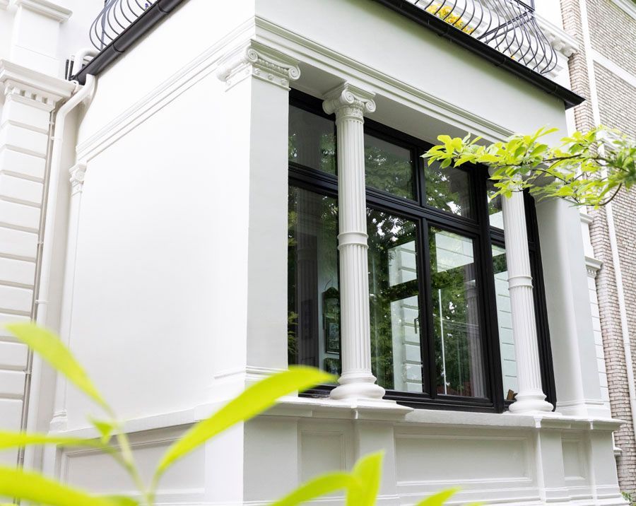 Ein weißes Gebäude mit Säulen und einem großen Fenster