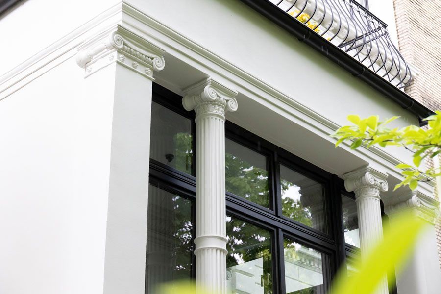 Ein weißes Gebäude mit Säulen und einem Balkon.