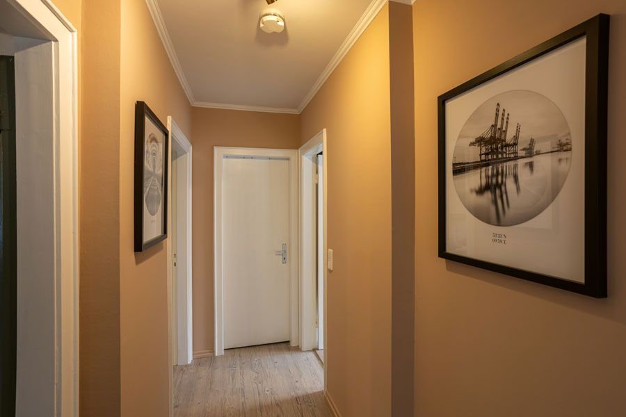 Ein Flur mit einem Bild an der Wand und zwei Türen.