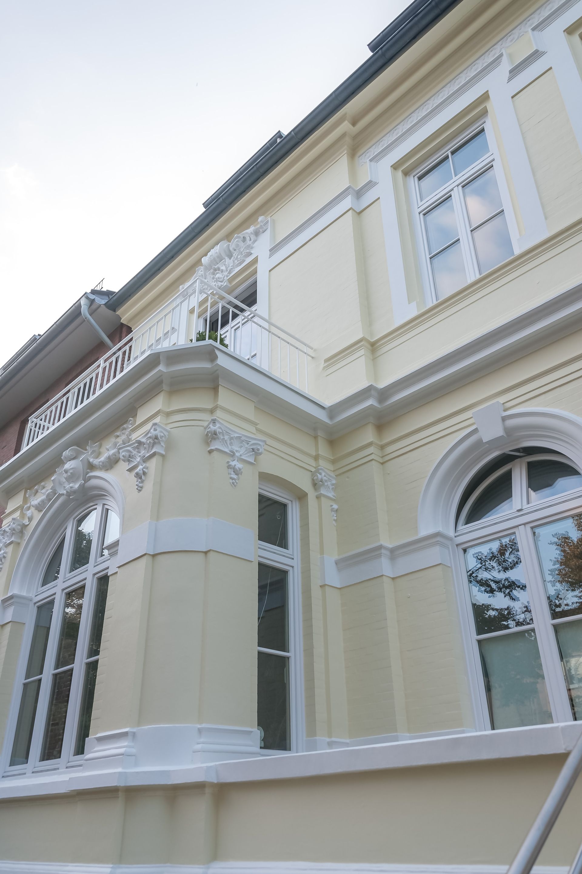 Ein Gebäude mit einem Balkon und vielen Fenstern