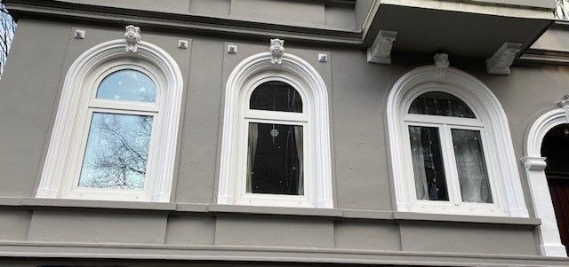 Ein Gebäude mit drei Bogenfenstern an der Seite.