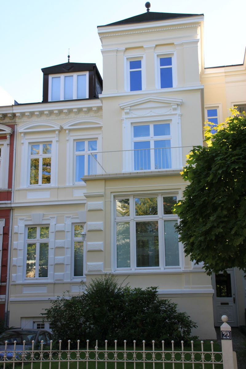 Ein großes weißes Gebäude mit einem Zaun davor