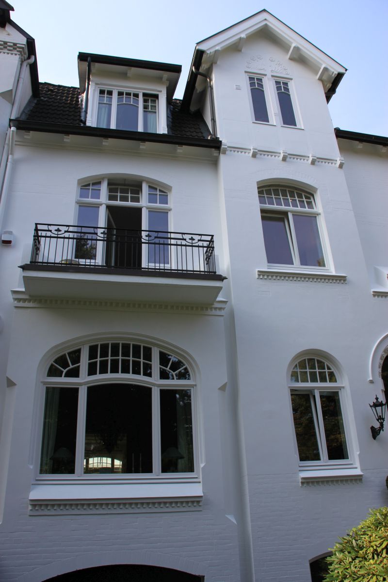 Ein weißes Gebäude mit einem Balkon im zweiten Stock