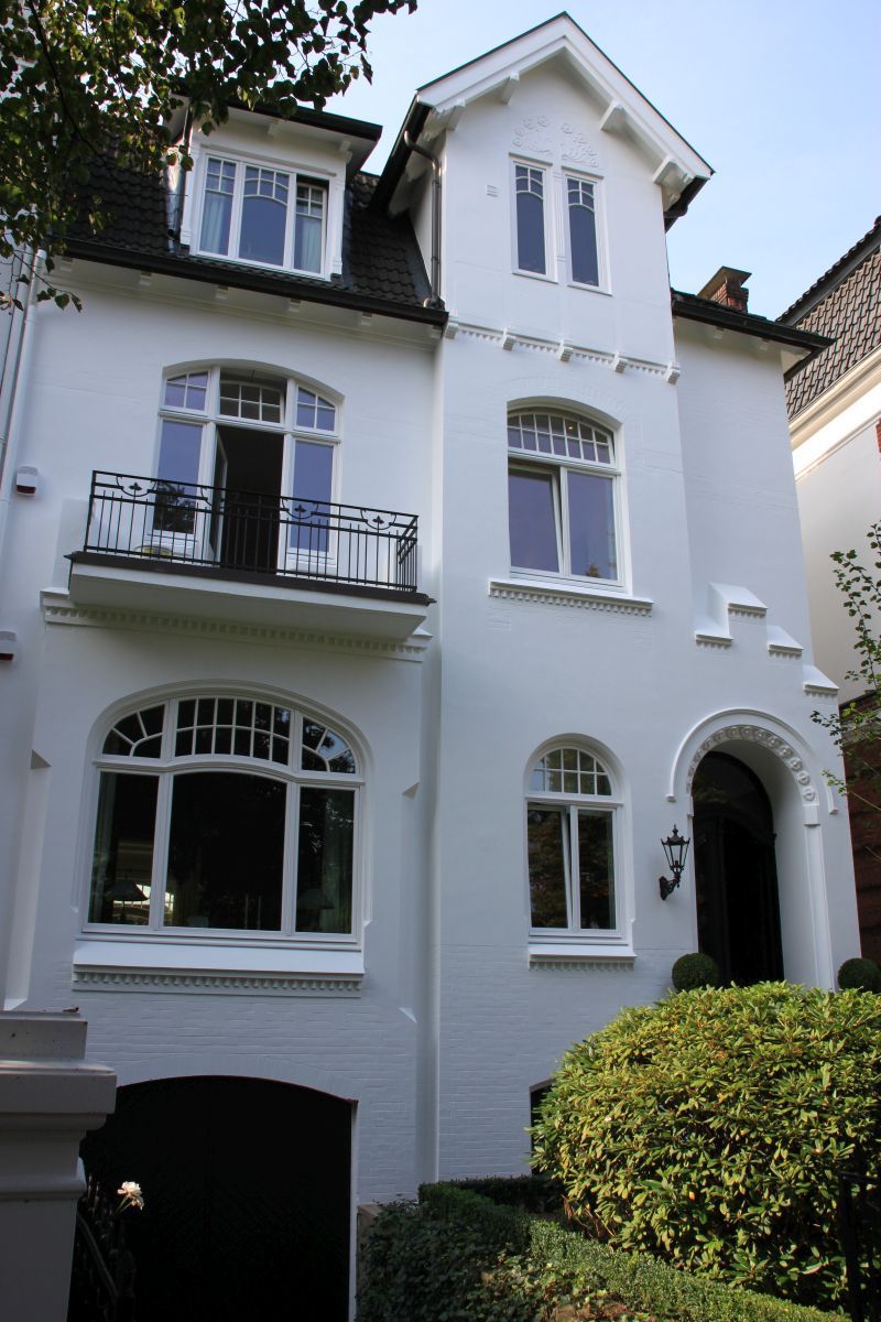 Ein weißes Haus mit einem Balkon im zweiten Stock