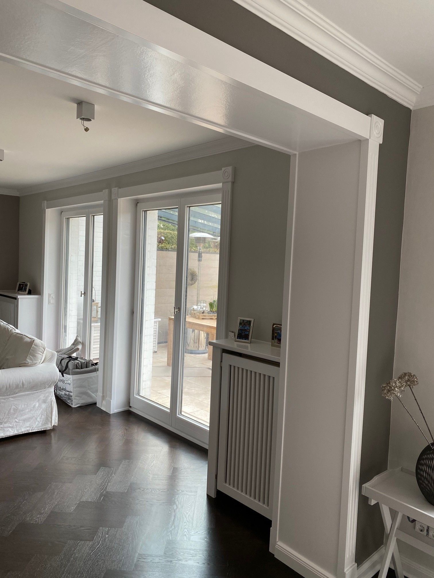 Ein Wohnzimmer mit Couch, Sessel, Tisch und Glasschiebetüren.