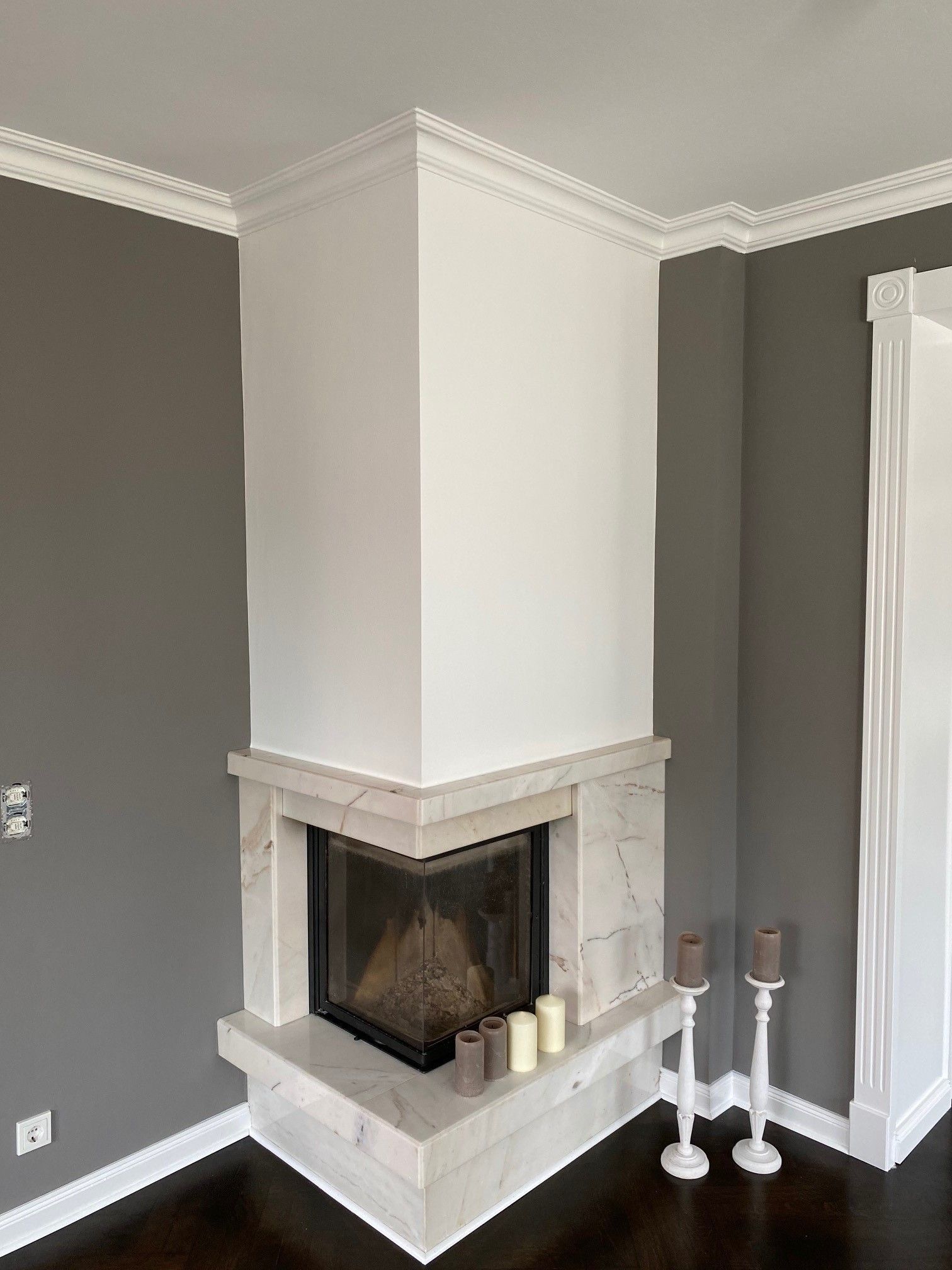 In der Ecke des Zimmers steht ein Kamin.