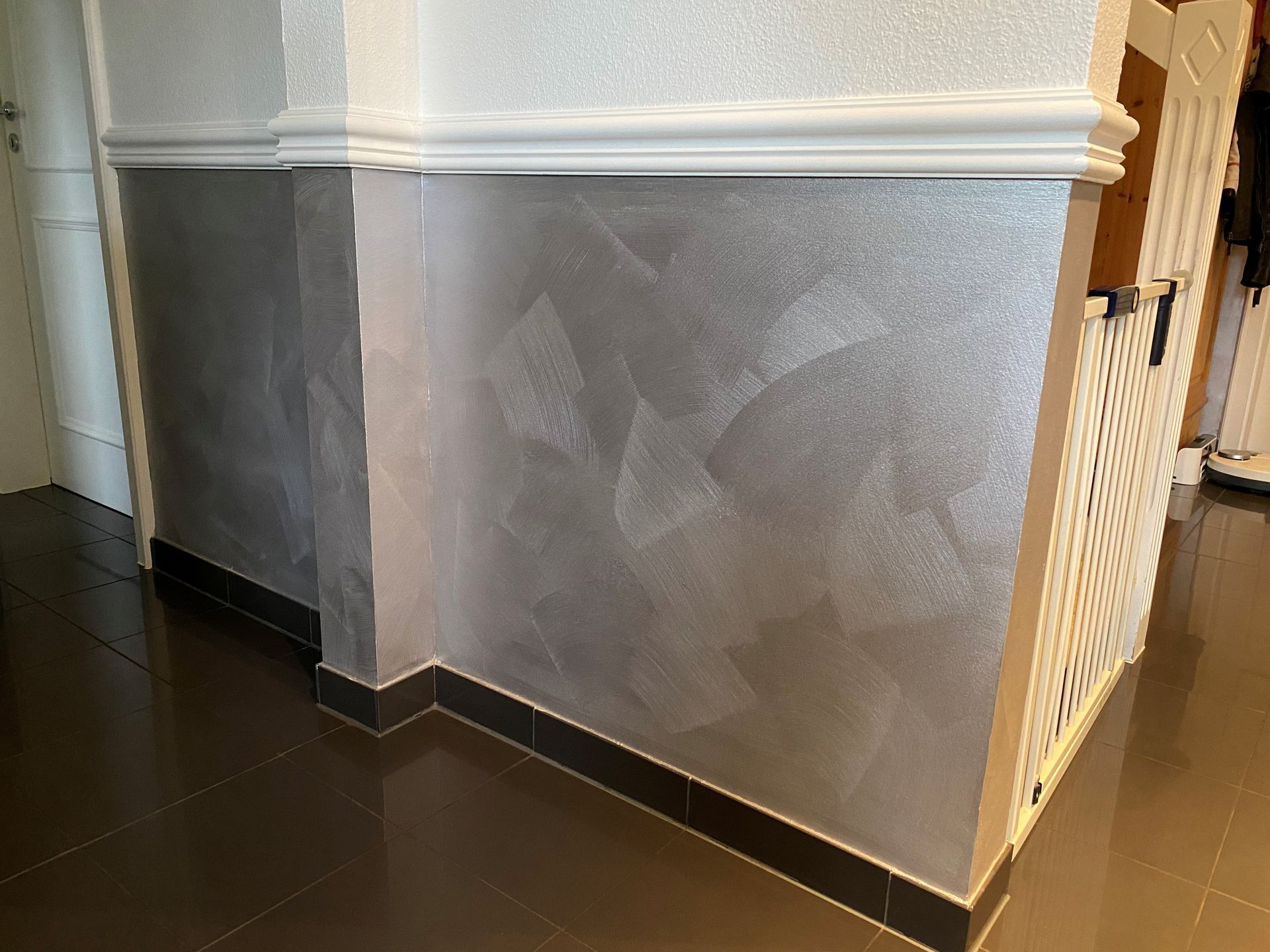 Ein Flur mit weißem Geländer und silberner Wand