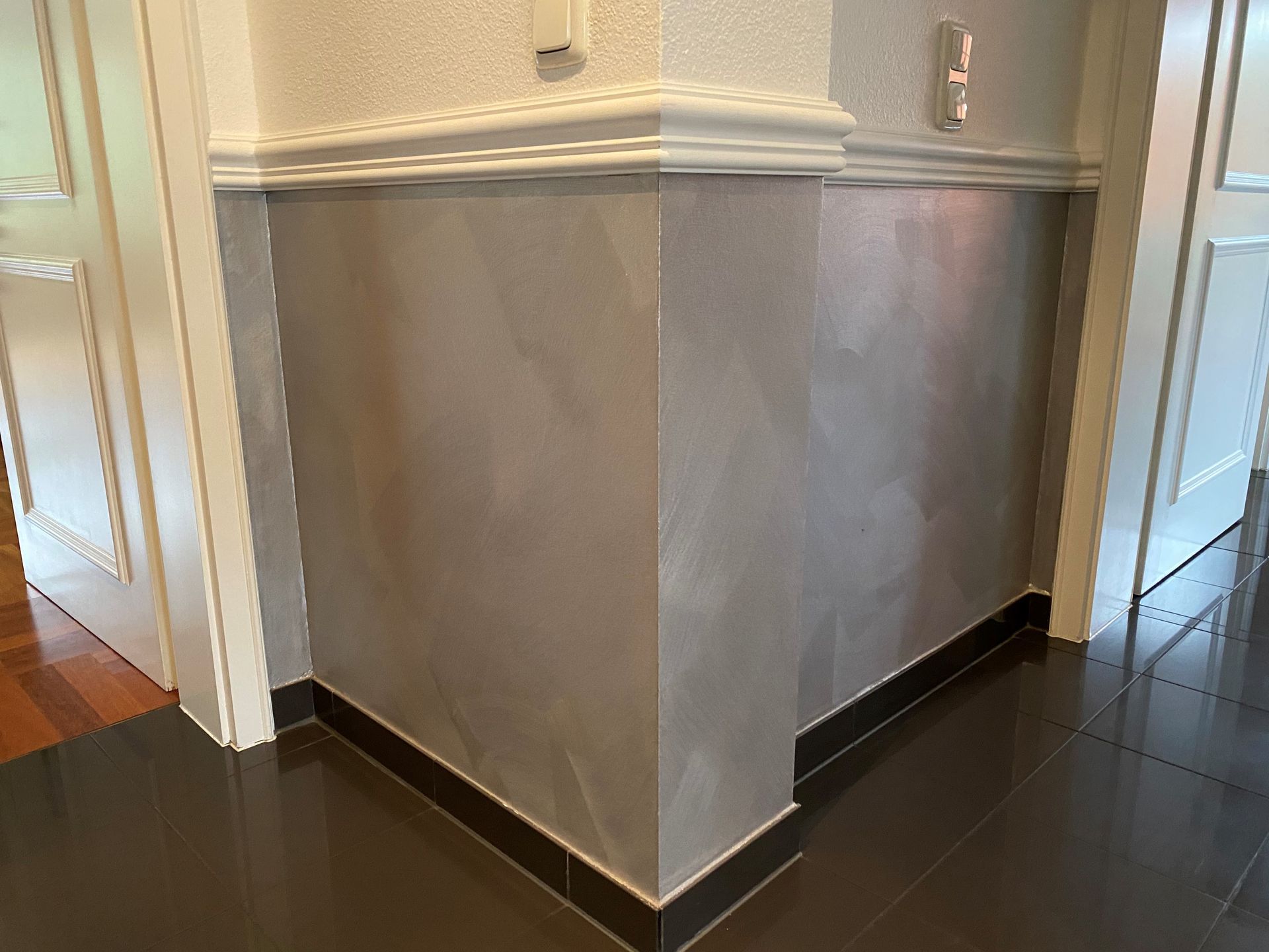 Ein Flur mit einer Wandecke und einer Tür.