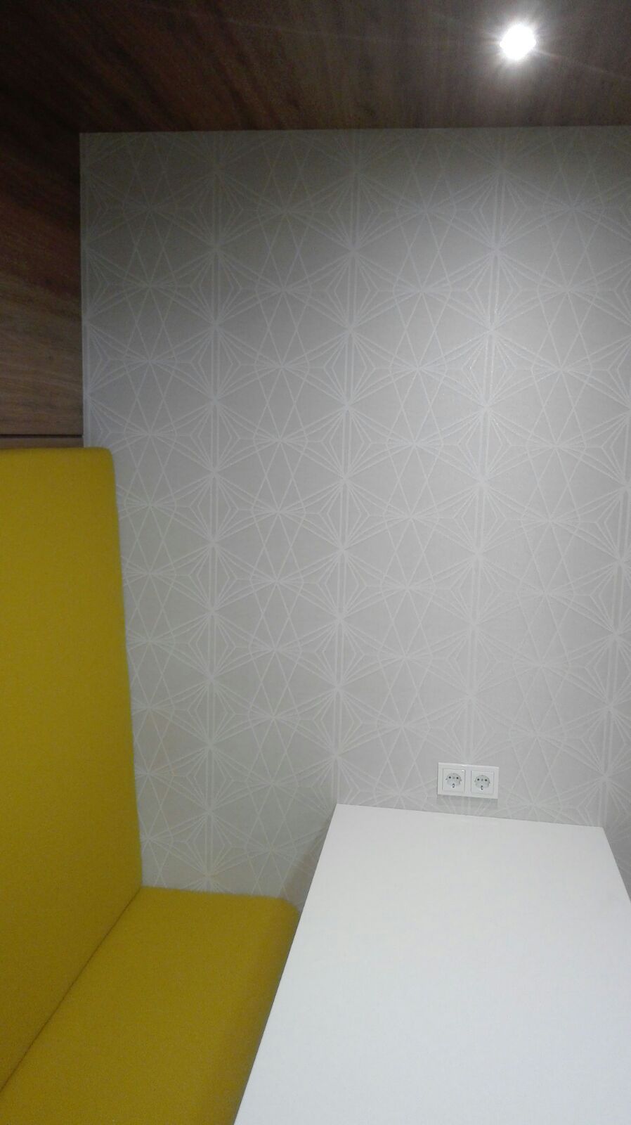 Ein Raum mit einer gelben Bank und einem weißen Tisch.