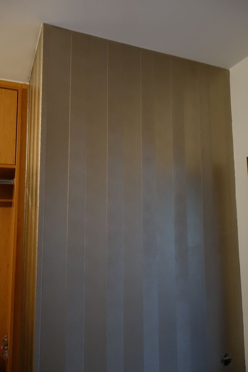 Eine Wand mit einem Streifenmuster in einem Raum