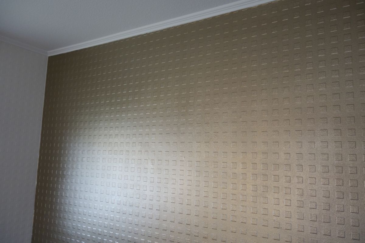 Eine goldene Wand mit einem Muster in einem Raum.