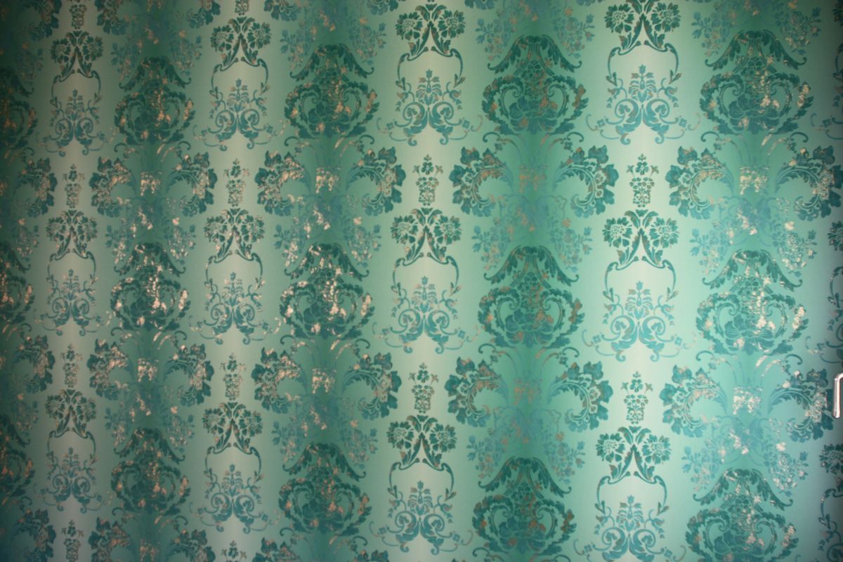 Eine grüne Wand mit einem Blumenmuster darauf
