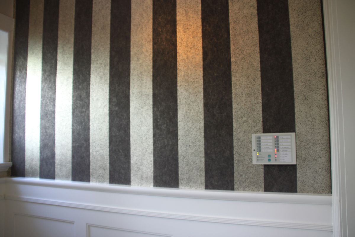 Ein Zimmer mit einer schwarz-weiß gestreiften Tapete an der Wand.