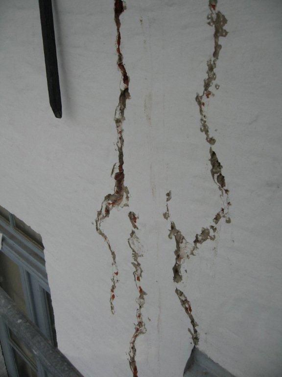 Eine weiße Wand mit Rissen