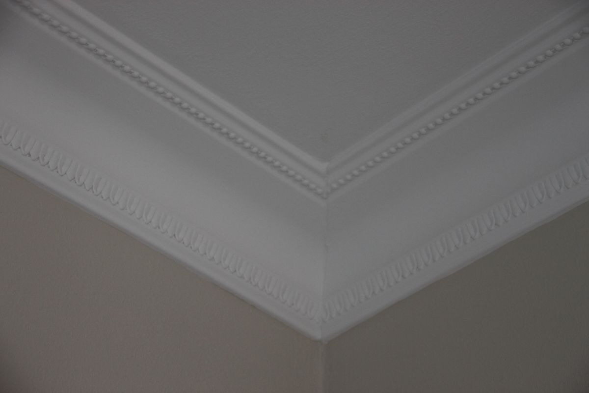 Eine Nahaufnahme einer Ecke einer Decke mit Zierleiste