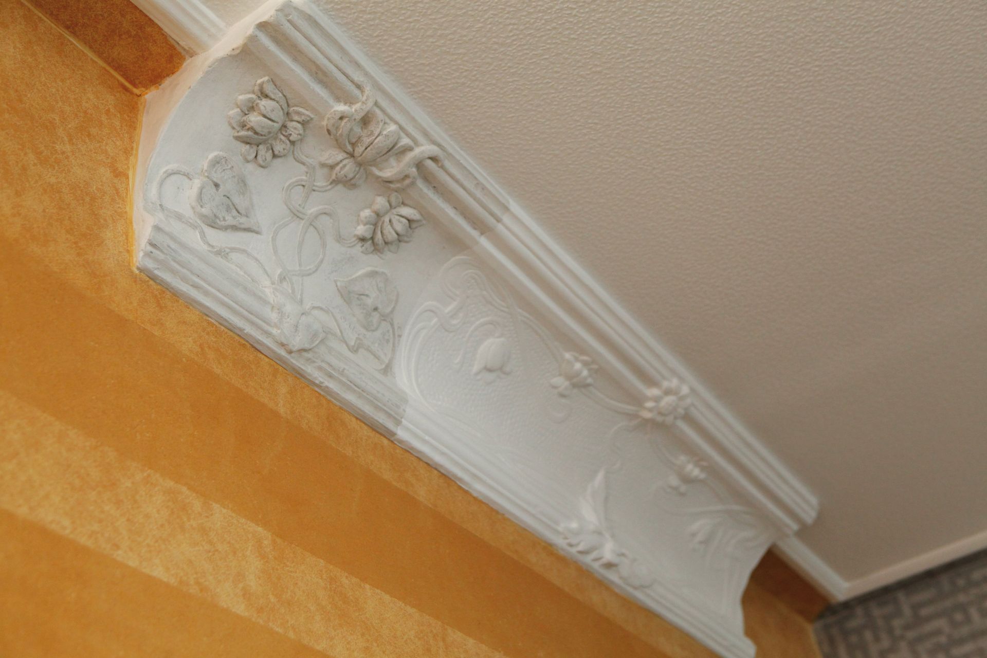 Ein weißes Gesims hängt von der Decke eines Raumes.